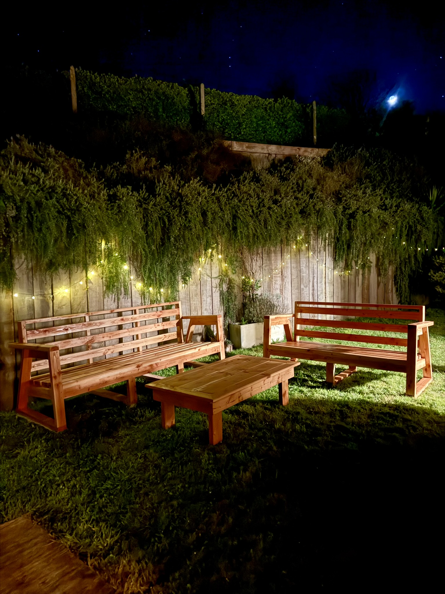 Salon de jardin en bois avec guirlandes de nuit